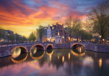 Fotobehang met oude herenhuizen op de hoek van de Keizersgracht en Leidsegracht in Amsterdam, met verlichte bruggetjes die de avond verlichten.