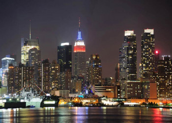 Fotobehang van de skyline van New York in de Nacht en zijn verlichte wolkenkrabbers.