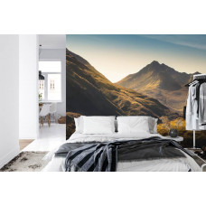 Een fotobehang met een serene ochtendweergave van bergen en een zachte zonsondergang, perfect voor een slaapkamer.