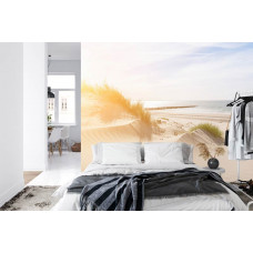 Een fotobehang van serene duinen en een strand met uitzicht op zee, perfect voor een slaapkamer.