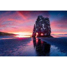 Fotobehang van Hvitserkur bij zonsondergang in IJsland, met de zee en de iconische drakenrots in beeld.