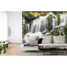 Een majestueus fotobehang van een waterval tussen bos en bergen, ideaal voor een woonkamer.