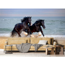 Een fotobehang van Shire-paarden die langs het strand galopperen, met de oceaan op de achtergrond, geplaatst in een woonkamer.