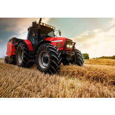 Fotobehang tractor op het land; een krachtige tractor maakt strobalen op een akker.