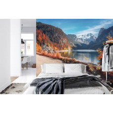 Een fotobehang met het kalme water van het Vorderer Gosausee in een berglandschap, afgebeeld in een slaapkamer.