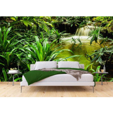 Een slaapkamer met een fotobehang van een waterval tussen tropische groene planten in een jungle.