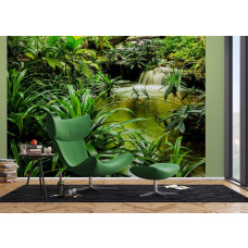 Een woonkamer met een fotobehang van een waterval tussen tropische groene planten in een jungle.