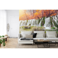 Een sfeervol fotobehang van een waterval in een herfstlandschap, perfect voor een huiskamer.