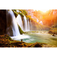 Fotobehang van een harmonieuze waterval die door een jungle stroomt, met weelderige groene vegetatie.