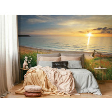 Een fotobehang met een zee bij zonsondergang en een strand in vliesbehangstijl voor een slaapkamer.