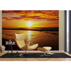 Een huiskamer met een fotobehang van een zonsondergang aan het strand boven zee.