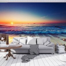 Een fotobehang van een strand bij zonsondergang aan zee voor de woonkamer.