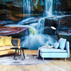 Een fotobehang van een waterval met rotsen voor de woonkamer.